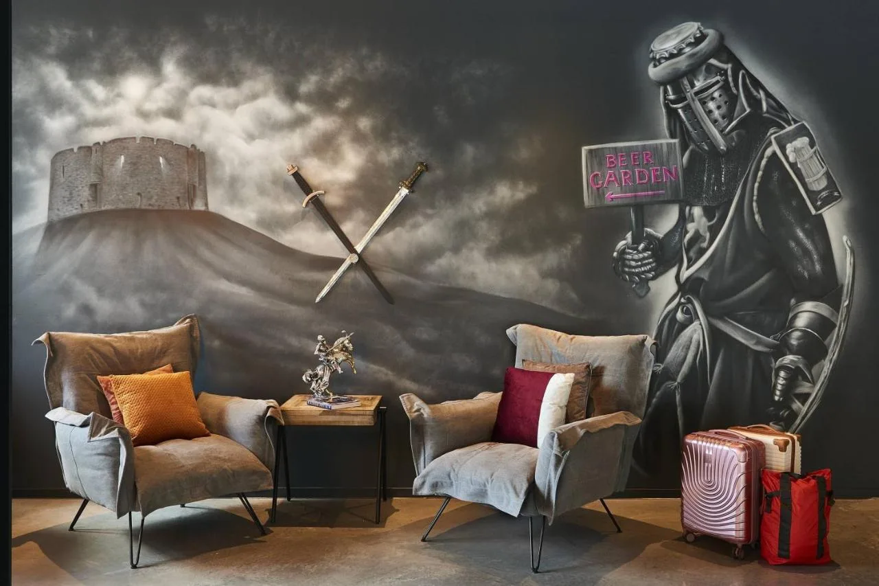 A room with two chairs and a clock on the wall at Moxy York, York