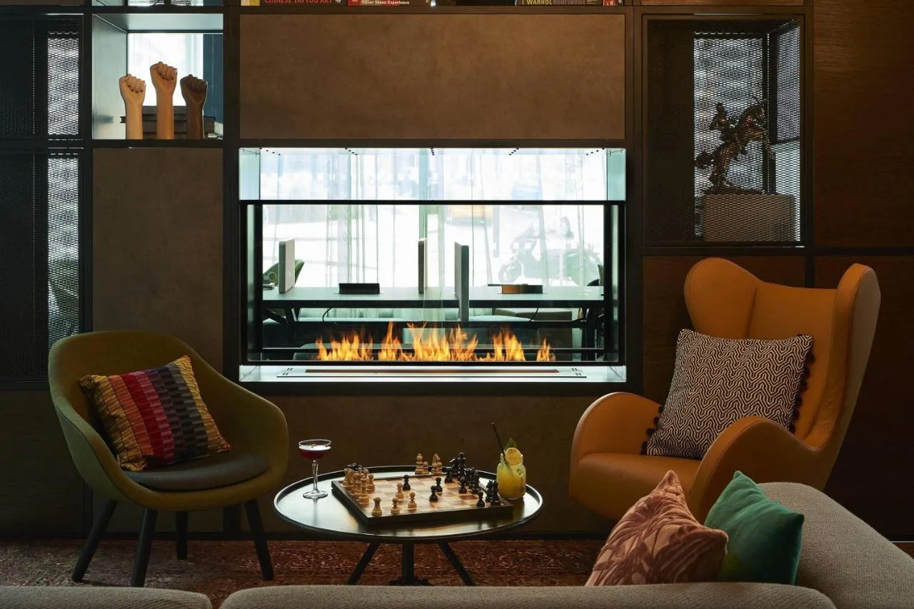 A living room with a fireplace and a chess board at Moxy York on Black Horse Lane