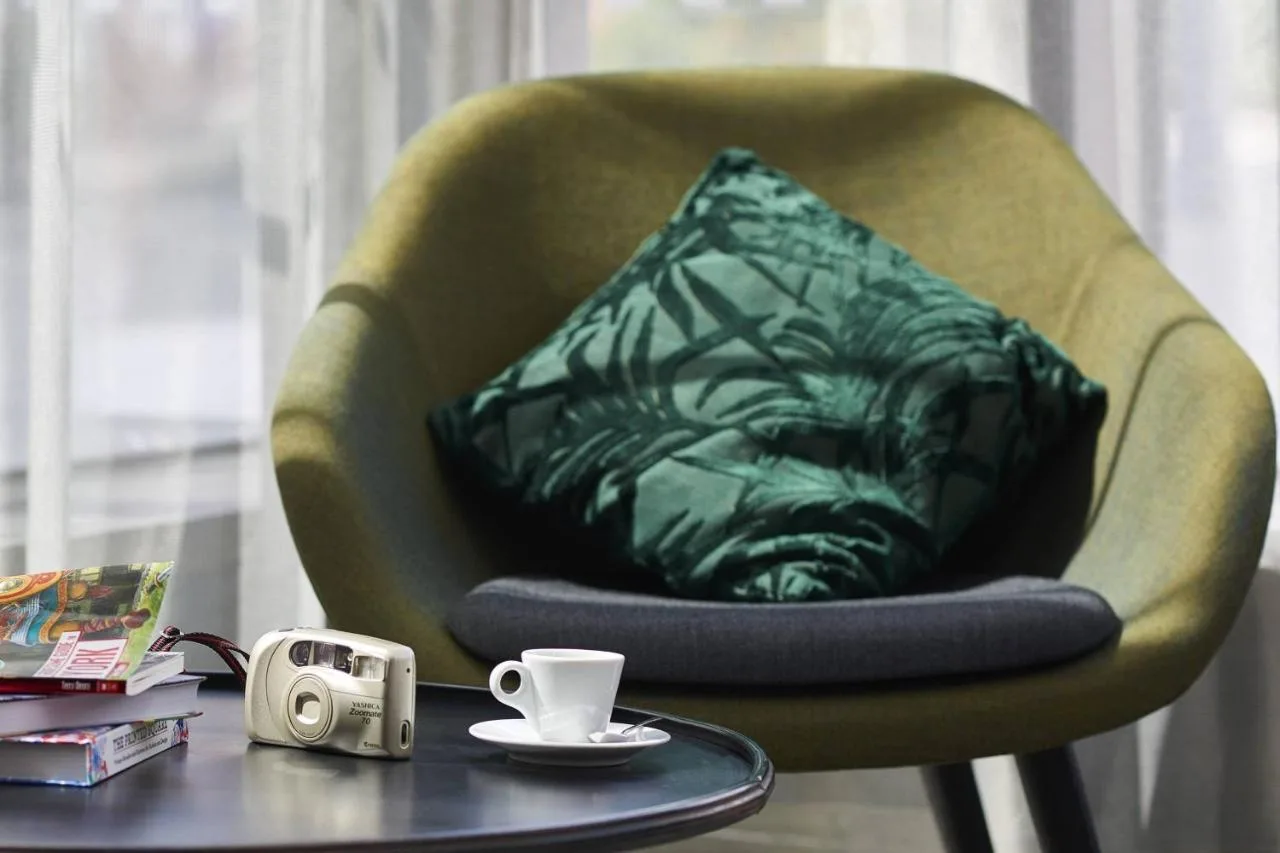 A green chair with a pillow at Moxy York, close to York Minster